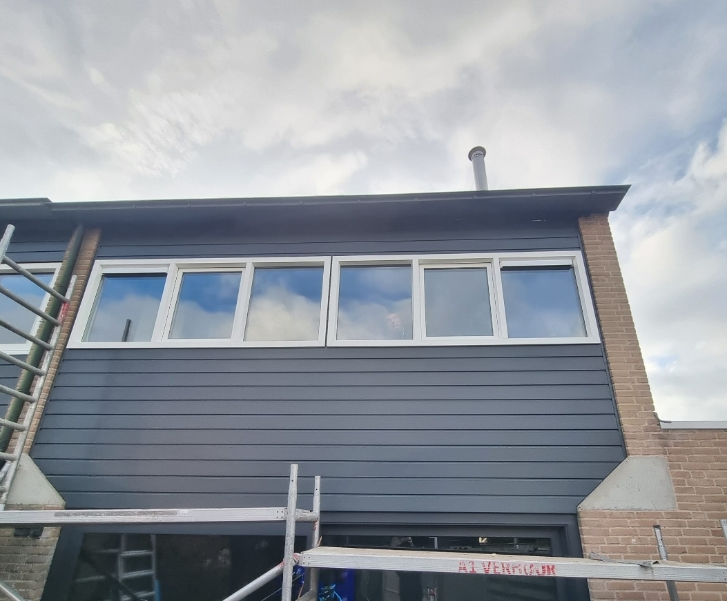 Bovenverdieping met nieuwe Keraliet bekleding en zes witte kozijnen, steiger ervoor