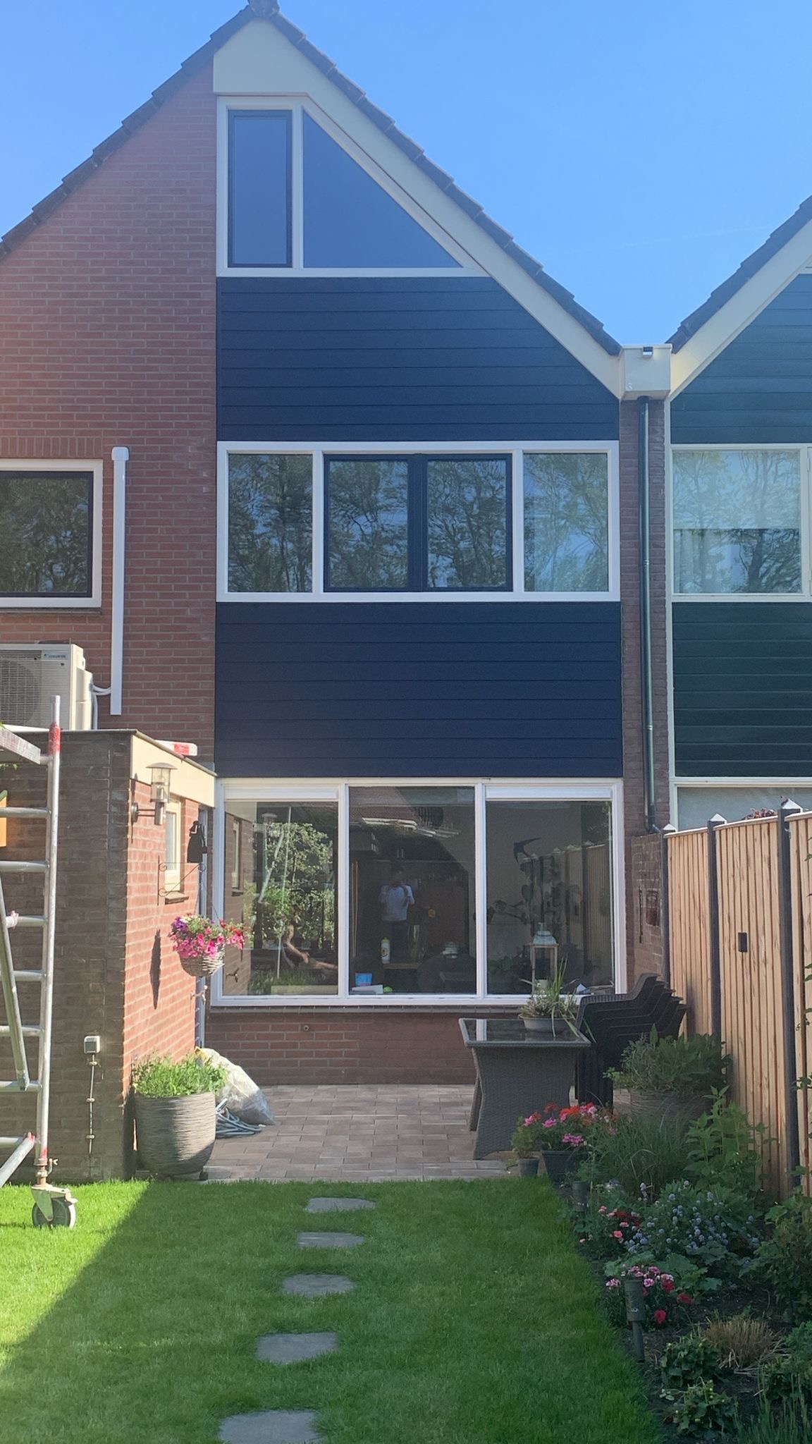 Achtergevel met donkerblauwe Keraliet gevelbekleding en nieuwe witte kunststof kozijnen